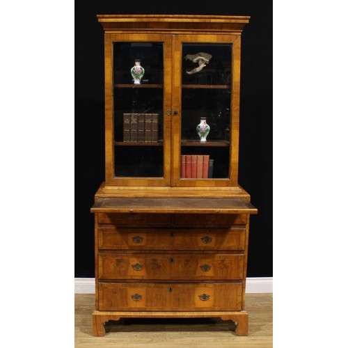 1360 - An 18th century and later walnut library bookcase, outswept cornice above a pair of glazed doors, en... 