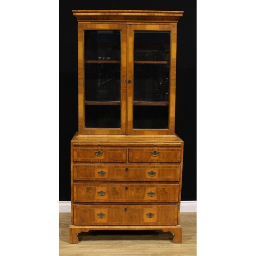 1360 - An 18th century and later walnut library bookcase, outswept cornice above a pair of glazed doors, en... 