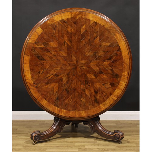 1439 - A Victorian mahogany and rosewood parquetry centre table, circular tilting top with segmented veneer... 