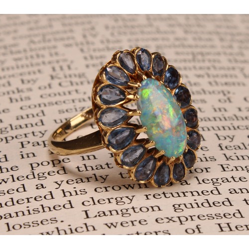 958 - An 18ct gold oval opal and tourmaline cluster ring, the central elongated oval cabochon opal within ... 