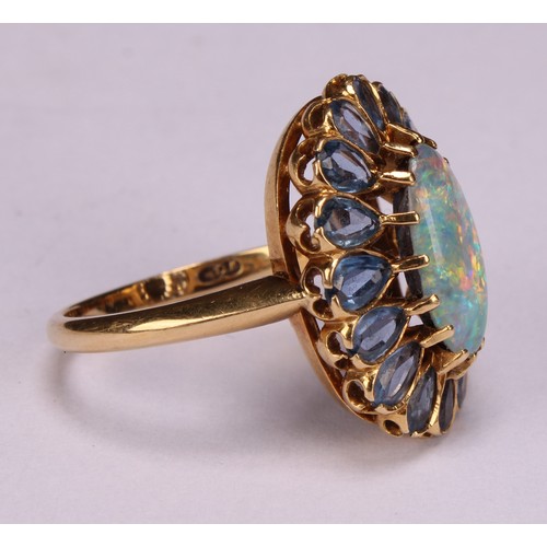 958 - An 18ct gold oval opal and tourmaline cluster ring, the central elongated oval cabochon opal within ... 