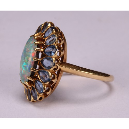 958 - An 18ct gold oval opal and tourmaline cluster ring, the central elongated oval cabochon opal within ... 