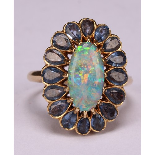 958 - An 18ct gold oval opal and tourmaline cluster ring, the central elongated oval cabochon opal within ... 