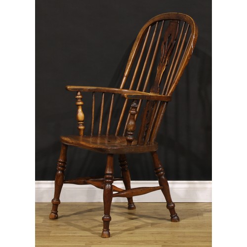 1379 - A 19th century East Midlands ash and elm Windsor elbow chair, hoop back, shaped and pierced splat, s... 