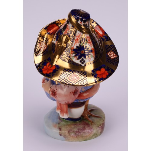 120 - A Royal Crown Derby Mansion House dwarf, standing, wearing a broad brimmed Imari solid gold band hat... 