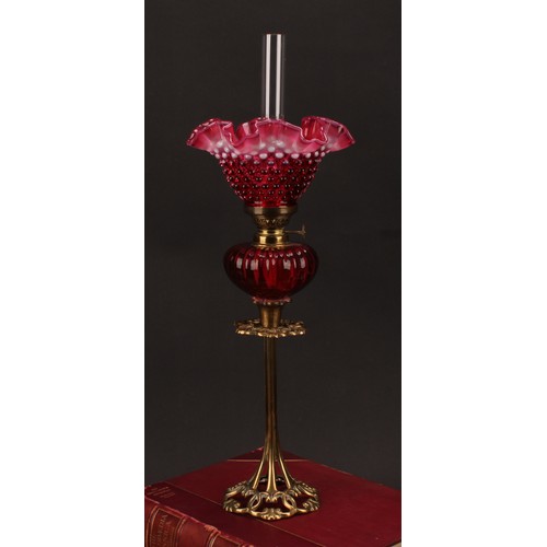 1302 - An Art Nouveau period brass oil lamp, the cranberry and vaseline glass frill top shade moulded with ... 