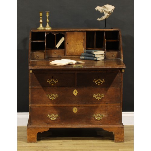 1188 - A George III oak bureau, fall front enclosing a well, a small door, small drawers and pigeonholes, a... 