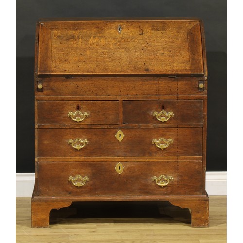 1188 - A George III oak bureau, fall front enclosing a well, a small door, small drawers and pigeonholes, a... 