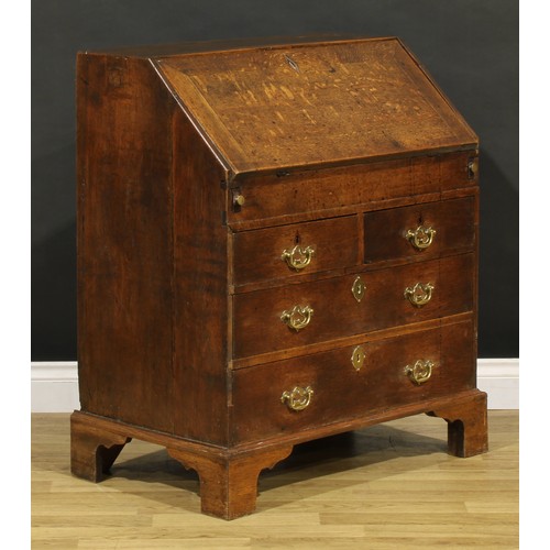 1188 - A George III oak bureau, fall front enclosing a well, a small door, small drawers and pigeonholes, a... 