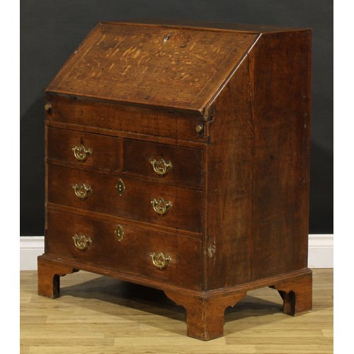 1188 - A George III oak bureau, fall front enclosing a well, a small door, small drawers and pigeonholes, a... 