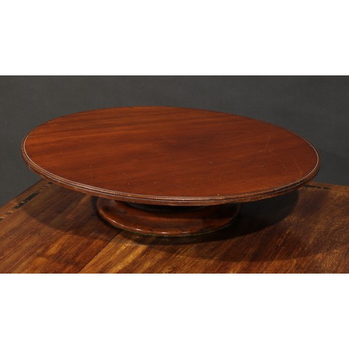 1387 - A 19th century Lazy Susan, the circular mahogany top turning on a weighted draft turned base, 53cm i... 