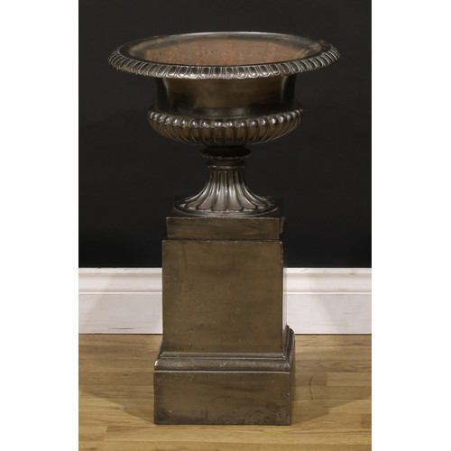 1465 - A late Victorian cast iron semi-fluted compressed-campana shaped garden urn and pedestal, of small a... 