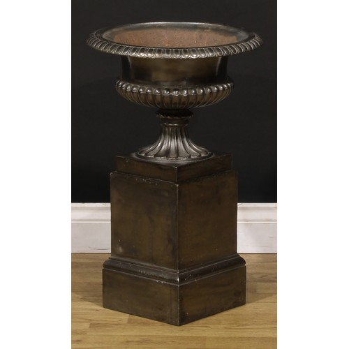 1465 - A late Victorian cast iron semi-fluted compressed-campana shaped garden urn and pedestal, of small a... 