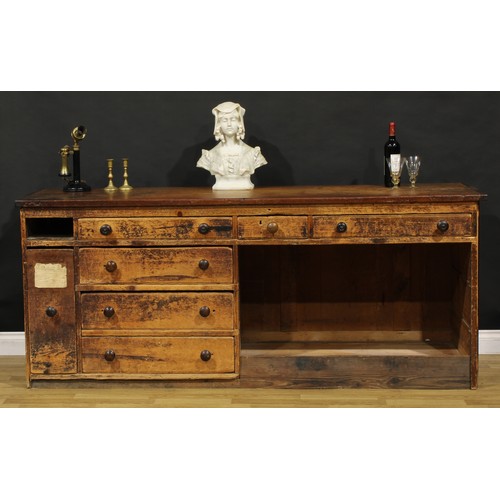 1438 - A Victorian mahogany and pine haberdashery shop counter, rectangular top above an arrangement of dra... 