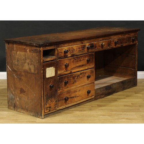 1438 - A Victorian mahogany and pine haberdashery shop counter, rectangular top above an arrangement of dra... 