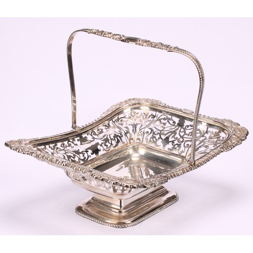 666 - A George V silver shaped rectangular swing-handled pedestal basket, pierced with foliate scrolls, ga... 