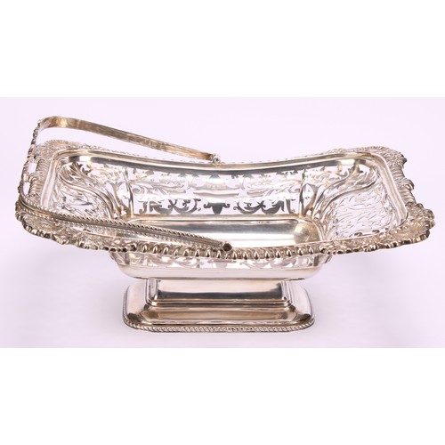 666 - A George V silver shaped rectangular swing-handled pedestal basket, pierced with foliate scrolls, ga... 