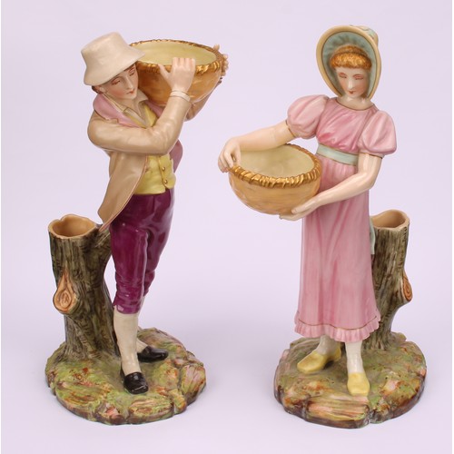 55 - A pair of Royal Worcester figural spill vases, modelled as a boy and girl, each carrying a basket, s... 