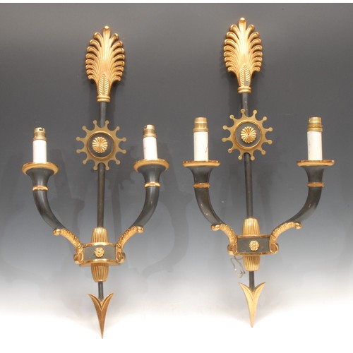 1294 - A pair of Empire style dark patinated and parcel gilt bronze two branch wall sconces, 66.5cm high, e... 