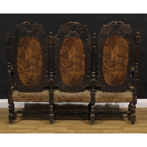 1197 - A late Victorian oak triple-chair-back sofa, stuffed-over upholstery, the back carved throughout wit... 