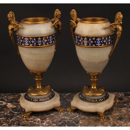 1243 - A pair of late 19th century French gilt bronze and champlevé enamel mounted onyx ovoid urns, the han... 