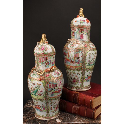 265 - A pair of Cantonese baluster vases and covers, painted in the famille rose palette with figures, bir... 