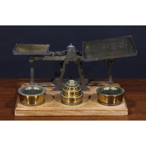 1298 - A set of Victorian oak and brass parcel post letter balance scales, the larger plateau inscribed wit... 