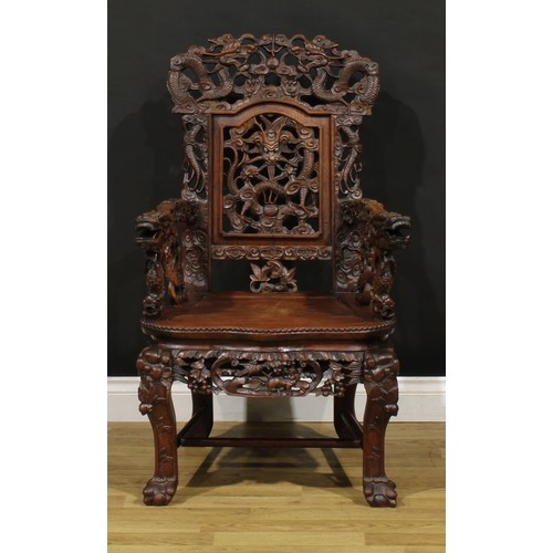 1228 - A Chinese hardwood armchair, carved throughout with dragons and stylised clouds, serpentine seat wit... 