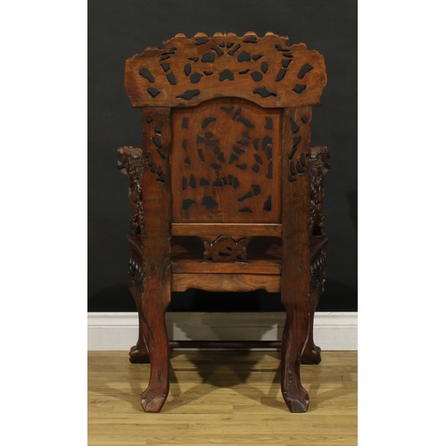 1228 - A Chinese hardwood armchair, carved throughout with dragons and stylised clouds, serpentine seat wit... 