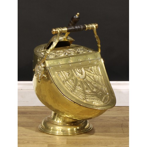 1285 - An Edwardian brass helmet shaped coal scuttle, embossed in the Neoclassical taste, 57cm high overall... 