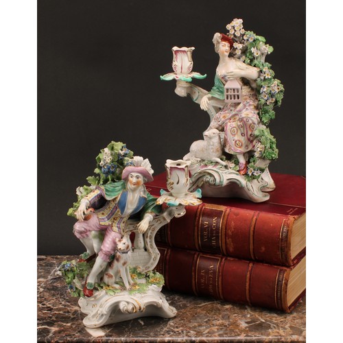 111 - A pair of Derby porcelain figural candlesticks, modelled as a shepherd and shepherdess, each seated ... 