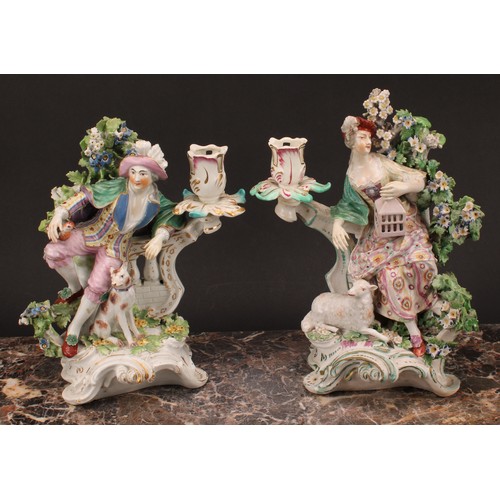 111 - A pair of Derby porcelain figural candlesticks, modelled as a shepherd and shepherdess, each seated ... 