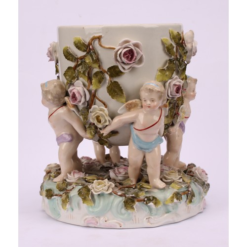 150 - A pair of Sitzendorf porcelain cache pots, each supported by four cherubs, the shaped circular base ... 