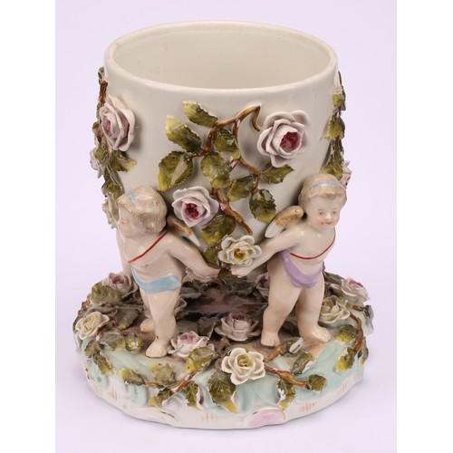 150 - A pair of Sitzendorf porcelain cache pots, each supported by four cherubs, the shaped circular base ... 