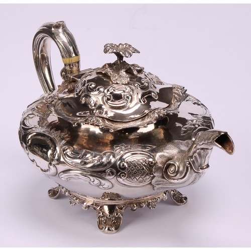 A William IV Rococo Revival silver compressed ovoid teapot, chased with ...