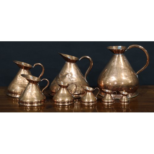 1282 - A set of eight 19th century graduated copper imperial measuring jugs, the largest measuring two gall... 