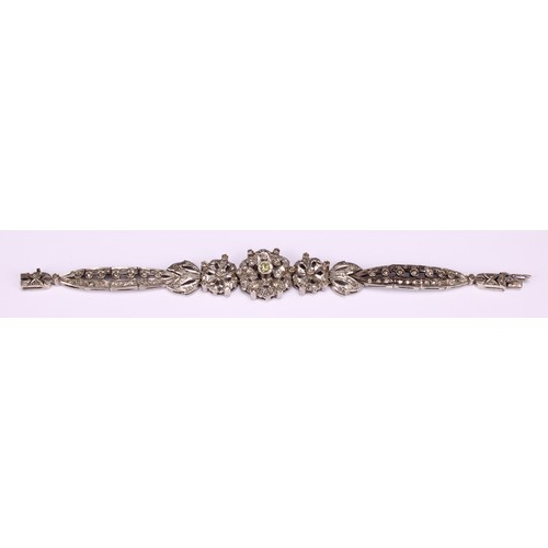 933 - A Belle Époque diamond and white metal bracelet, centered with three graduated flowerheads flanked b... 