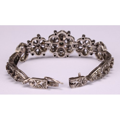 933 - A Belle Époque diamond and white metal bracelet, centered with three graduated flowerheads flanked b... 