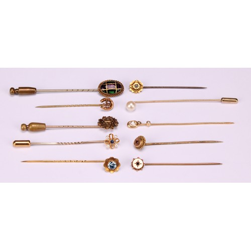 970 - Stick Pins - a 9ct gold flowerhead stick pin, illusion set with a single stone; a 9ct Three Legs of ... 