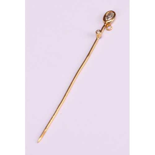 970 - Stick Pins - a 9ct gold flowerhead stick pin, illusion set with a single stone; a 9ct Three Legs of ... 