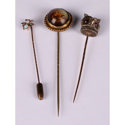 980 - Stick Pins - An Essex rock crystal reverse intaglio stick pin, decorated with a fox mask, rope twist... 