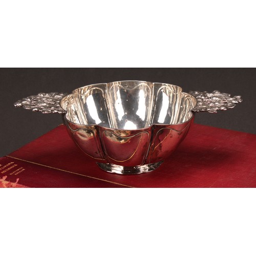 609 - A Dutch silver brandy bowl, of typical lobed design, lug handles pierced and chased with putto and f... 