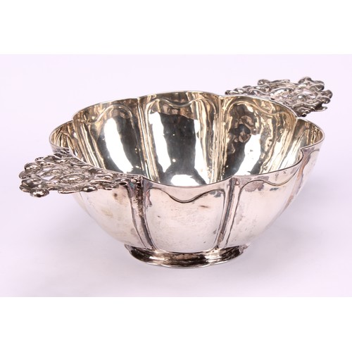 609 - A Dutch silver brandy bowl, of typical lobed design, lug handles pierced and chased with putto and f... 