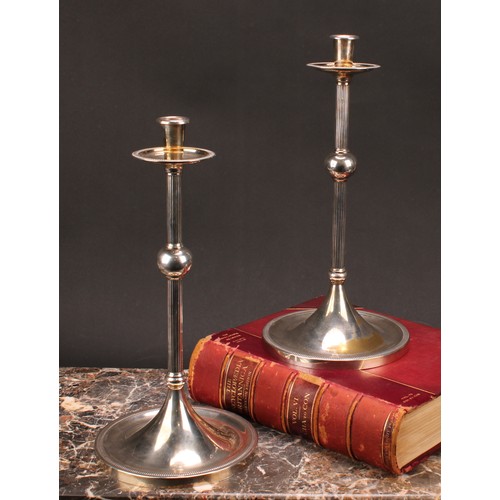 576 - Interior Design - a pair of large E.P.N.S candlesticks, of Christopher Dresser influence, broad drip... 