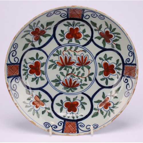 12 - A pair of 18th century Dutch Delft plates, painted in polychrome, with flowers and table, 22cm diame... 