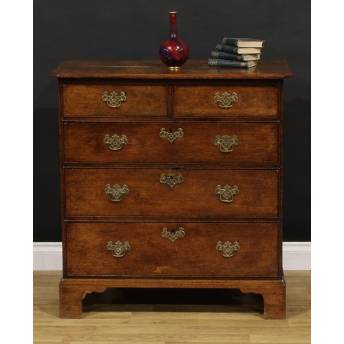 1192 - A George III oak chest, rectangular top with canted foreangles, above two short and three long gradu... 