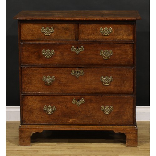 1192 - A George III oak chest, rectangular top with canted foreangles, above two short and three long gradu... 