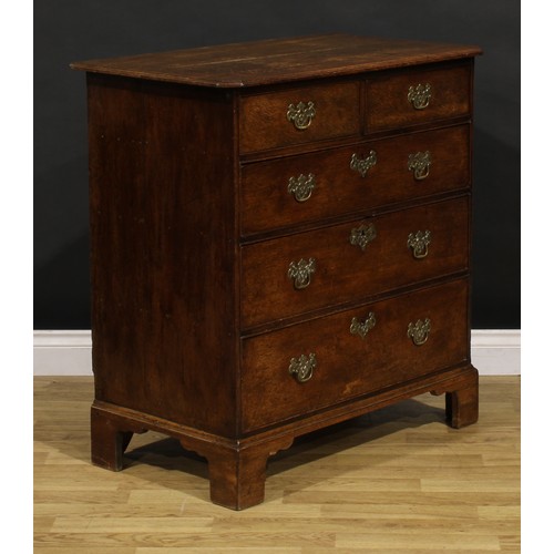 1192 - A George III oak chest, rectangular top with canted foreangles, above two short and three long gradu... 