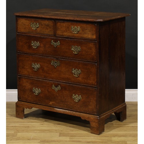 1192 - A George III oak chest, rectangular top with canted foreangles, above two short and three long gradu... 