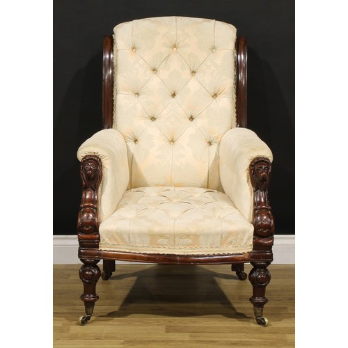 1353 - A Victorian mahogany library chair, stuffed-over deep-button upholstery, the hand rests carved as li... 